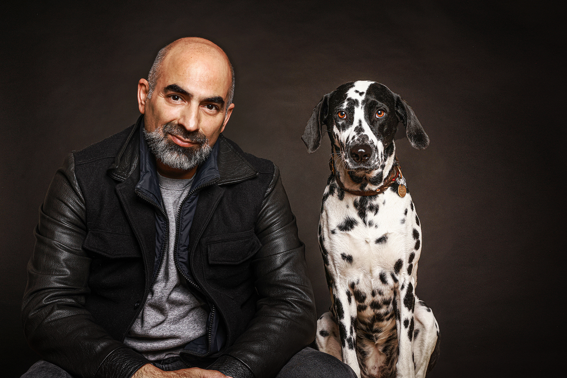 Mann mit Dalmatiner beim Hundshooting mit Dalmatiner, ruhig inszeniert im Fotostudio in Hamburg
